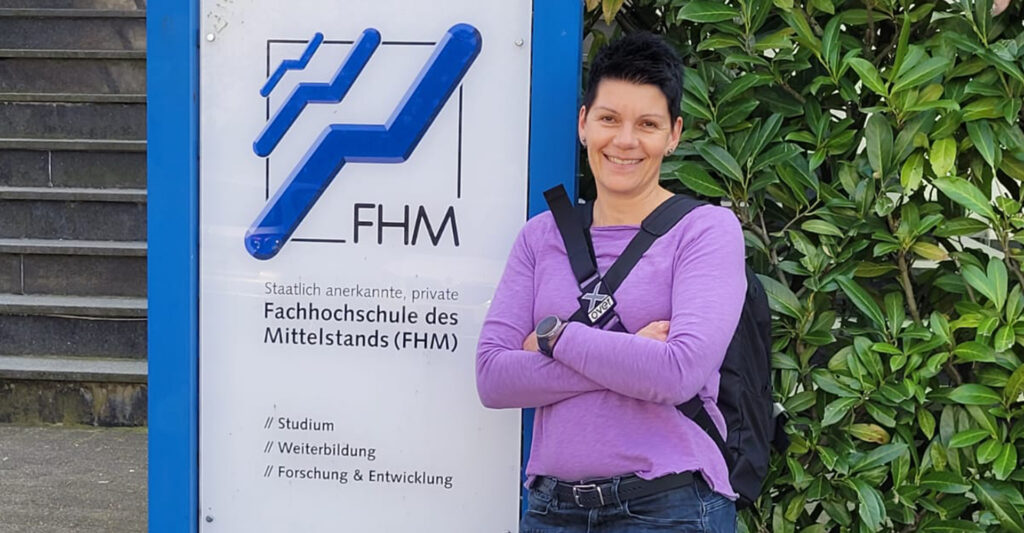 Bettina Kleinschmidt steht vor dem Schild der Fachhochschule des Mittelstands