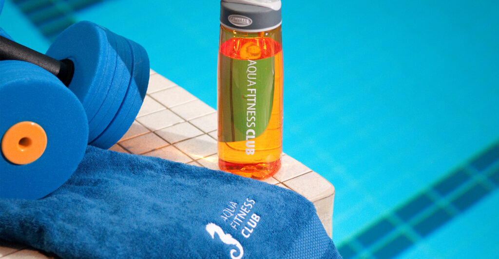 Hantel, Handtuch und Wasserflasche am Beckenrand