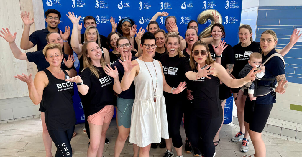 Das AquaFitnessClub Team winkt freudig