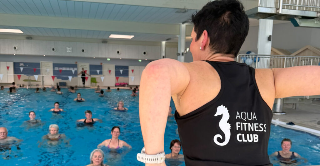 Trainerin Bettina Klineschmidt am Beckenrand, bringt Menschen im Wasser LymphJogging bei